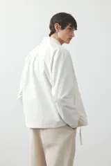 Pantalón color beige de popelina de algodón, corte ancho, con cintura elástica ajustable con cordón, bolsillos laterales y traseros.