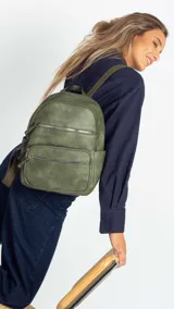 Mochila color rosa de símil cuero con bolsillos frontales con cierre. Tiene asa de mano rígida y correas regulables.