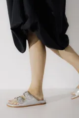 Sandalias marrones de cuero vacuno con doble tira y hebillas metálicas ajustables.