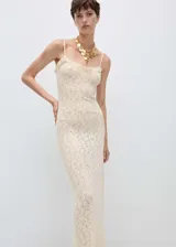 Vestido largo de punto fino color crema, con tirantes finos, cuello escotado, terminaciones con volantes y detalles calados.