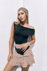 Remera negra con corte asimétrico en el escote, dejando un hombro al descubierto.