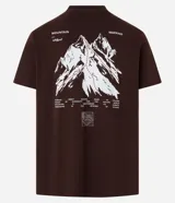 Remera marrón de algodón, corte clásico, con cuello redondo y manga corta. Presenta un pequeño estampado con lettering y un logo en el pecho.