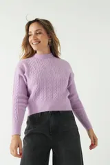 Sweater color camel de punto con diseño de ochos en el frente y mangas, cuello semi alto y corte al cuerpo.