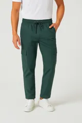 Pantalón cargo negro de corte holgado, con cintura elástica ajustable con cordón, bolsillos laterales y bolsillos tipo parche con solapa en los muslos.