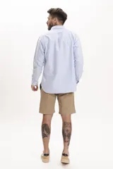 Camisa celeste de lino, de corte clásico, manga larga y cuello abotonado.