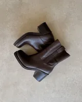 Botines de cuero vacuno color marrón chocolate, con caña media, punta cuadrada y taco bloque.