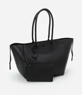 Bolso shopper grande de cuero sintético negro con asas medianas y cierre de cremallera. Incluye un dije colgante en forma de corazón y una pequeña cartera extra.