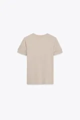 Remera color beige de corte recto, cuello redondo y mangas cortas con dobladillo.