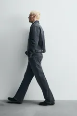 Pantalón de jean de tiro medio, color gris oscuro con efecto lavado, corte ajustado en la parte superior y acampanado desde la rodilla, con cinco bolsillos y cierre frontal con cremallera y botón.