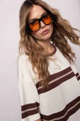 Vestido largo tejido a rayas horizontales marrones y crudas, con tajos a los costados y mangas cortas. Diseño oversize.