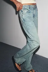 Pantalón de jean celeste de corte recto y tiro medio, con cinco bolsillos y cierre frontal con cremallera y botón metálico.