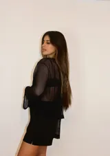 Sweater calado negro de manga ancha y cuello bote, fabricado en un diseño moderno y versátil.