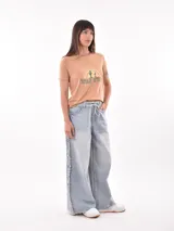 Remera color ladrillo con estampa de cactus y arcoíris con la frase "Welcome to the Wild West".