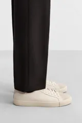 Zapatillas blancas de cuero con detalles en gamuza en la puntera y el talón. Cierre con cordones.