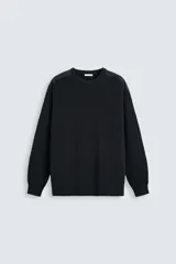 Jersey negro de punto con cuello redondo y manga larga. Presenta parches combinados en hombros y codos.
