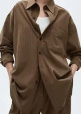 Camisa marrón con rayas verticales finas, de corte oversize, manga larga con puños abotonados, cuello camisero, bolsillo de parche en el pecho y cierre frontal con botones.