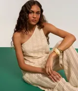 Blusa de algodón color crema con textura de rayas verticales y escote asimétrico de un solo hombro.