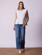 Blusa blanca texturizada de la marca Marissa Olivia. Presenta apliques de crochet en la parte delantera y un detalle fruncido en el ruedo.