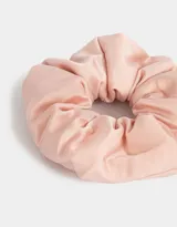 Gomita de pelo color rosa claro, confeccionada en tela satinada con efecto puffy.