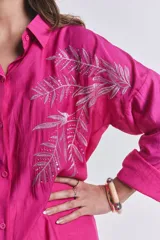Camisa fucsia oversize con bordado de hojas en el frente.