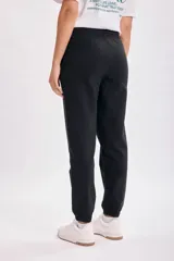 Pantalón de jogging negro con cintura elástica y cordón ajustable.
