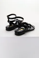 Sandalias bajas color marrón con estampado de piel de serpiente, tira delantera con detalle de hebillas y tira trasera con hebilla metálica.