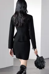 Minifalda negra de punto liso, de tiro alto y cintura elástica.