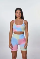 Conjunto deportivo de calza ciclista y top con estampado tie-dye en tonos pastel: rosa, celeste, verde y amarillo. El top es de breteles finos y tiene el logo 'bk.' estampado en el frente.
