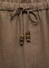 Pantalón negro de lino con diseño crop y jogger, tiro medio, cintura elástica con lazo, dos bolsillos laterales y dos bolsillos de ribete en la parte posterior.
