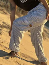 Pantalón de tela rayada rosa y blanco, de corte amplio y cintura elastizada.