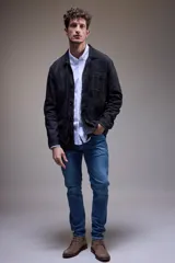 Campera tipo camisa de cuero negro con cuatro bolsillos frontales con solapa y cierre con botones a presión.
