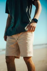 Bermuda color beige con cordón ajustable en la cintura y logo bordado en la pierna derecha.