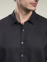 Camisa negra de lino, de manga larga y corte clásico.