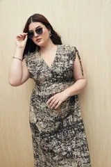 Vestido largo negro con estampado de líneas verticales blancas, escote en V, mangas cortas con lazo ajustable y corte fluido.