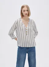 Camisa holgada de viscosa con estampado de rayas verticales en blanco y negro, cuello en V y mangas 3/4 con detalle de botones.