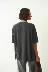 Remera gris con mangas cortas, cuello redondo y estampado con diseño abstracto en el frente.