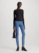 Jeans de denim elástico de tiro alto, corte skinny, color azul medio. Cuenta con bragueta con cremallera, diseño de cinco bolsillos y herrajes de Calvin Klein.