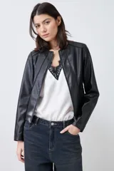 Chaqueta corta de cuero sintético color negro, con cuello redondo y cierre frontal. Presenta detalle de pasamanería en hombros y cuello.