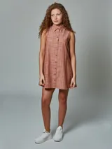 Vestido corto sin mangas, con cuello camisero y abotonadura frontal, confeccionado en lino a rayas color ladrillo.
