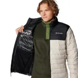 Campera puffer Columbia Powder Lite II, color beige con canesú negro, cierre frontal completo, bolsillos laterales con cierre y logo de la marca bordado en el pecho.