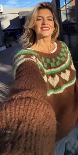 Sweater de punto color gris con diseño de corazones rosas y cuello con diseño geométrico.