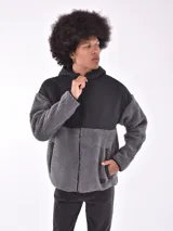 Campera con capucha, color gris oscuro, con paneles de tela tipo polar y tela lisa.