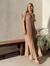 Vestido largo color beige, de tejido calado, escote en V, manga corta y corte holgado.