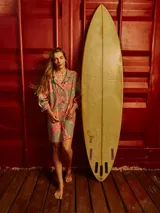 Vestido camisero de lino con estampado de palmeras en tonos rosados y verdes.