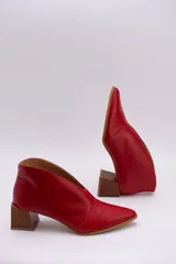 Botines color peltre de cuero con taco de madera y corte en V en el frente.