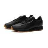 Championes Reebok Classic Leather negros de cuero con suela de goma color caramelo.