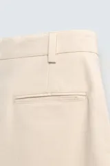 Bermuda color beige de corte recto, confeccionada en tejido de algodón con estructura canvas. Cuenta con bolsillos frontales y traseros de doble vivo.