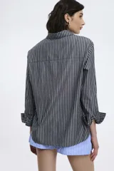 Camisa a rayas verticales rojas y blancas, de corte recto, con cuello clásico, manga larga y bolsillo en el pecho.