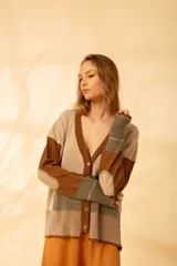 Cárdigan tejido con diseño de bloques de color en tonos marrón, beige y verde. Tiene cuello en V, cierre con botones y mangas largas.