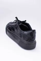 Zapatillas bajas color marrón con textura simil cuero de cocodrilo, cordones al tono y suela de goma blanca con detalle marrón.